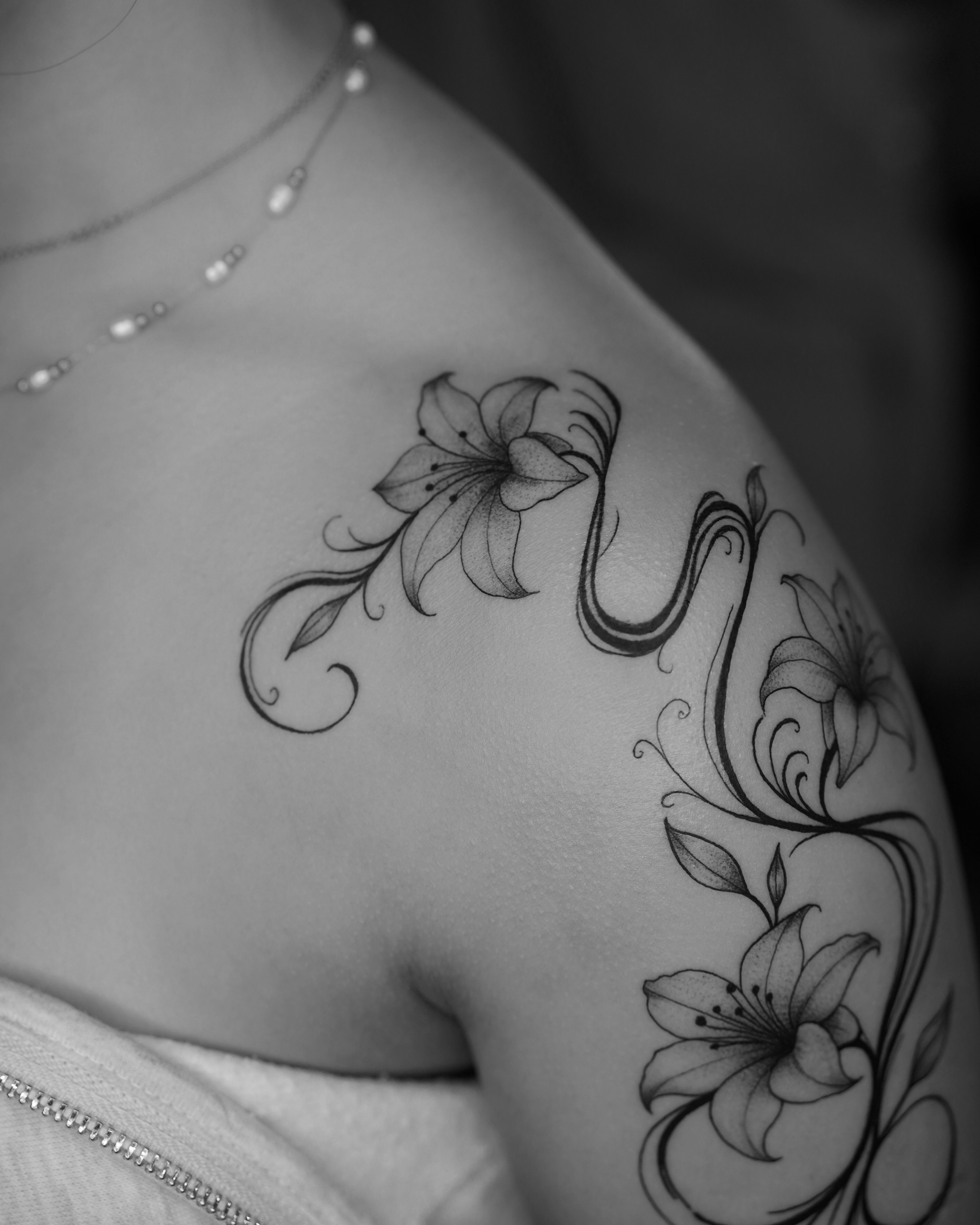 Floral fine line shoulder tattoo with delicate botanical linework
