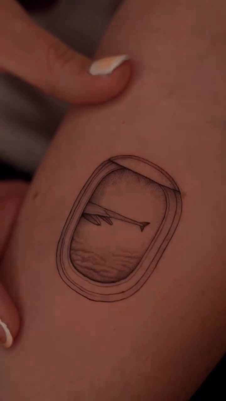 Airplane window view fineline tattoo showing detailed miniature scene
